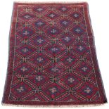 A Belouch rug with red ground, 53 by 33ins. (134 by 84cms.) (see illustration).