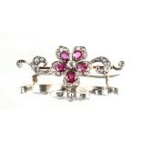 A Belle Epoque ruby & diamond floral brooch, the five petals set with a cut ruby flanked by pave set