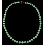 A Chinese jadeite single row bead necklace, the fifty-three individually strung graduated beads with