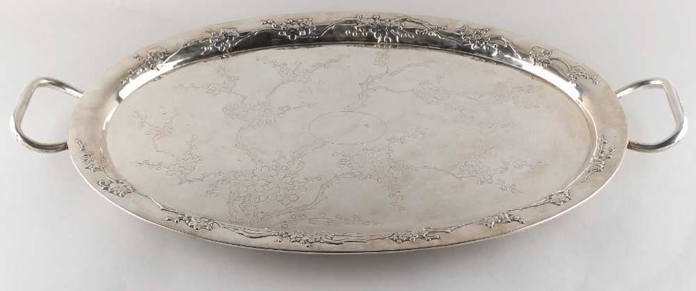 A Chinese silver two-handled oval tray, late 19th century, with engraved prunus centre within a