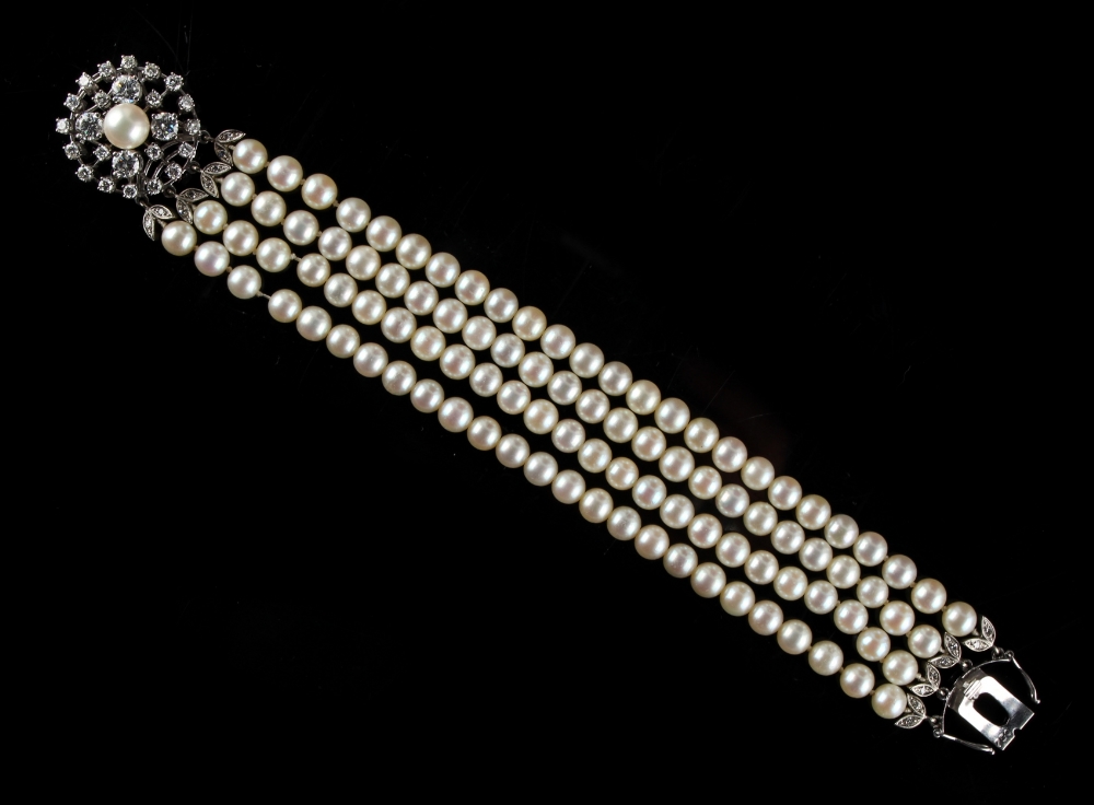 A pearl uniform four row bracelet with diamond circular floral clasp, the pearls approximately 6.0mm