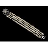 A pearl uniform four row bracelet with diamond circular floral clasp, the pearls approximately 6.0mm