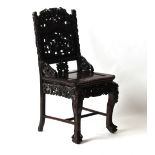 A Chinese profusely carved hongmu side chair, late 19th / early 20th century, with panelled seat &