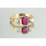 An 18ct yellow gold ruby & diamond three stone ring, the centre certificated unheated Thai cushion