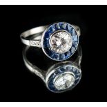 A platinum or white gold sapphire & diamond target cluster ring, the centre millegrain collet set