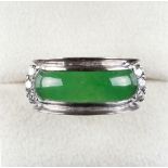 An 18ct white gold untreated jadeite & diamond ring, set with a curved & rounded jadeite panel