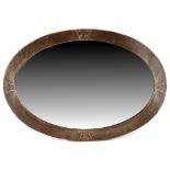 Property of a deceased estate - an Arts & Crafts hammered copper oval framed wall mirror with