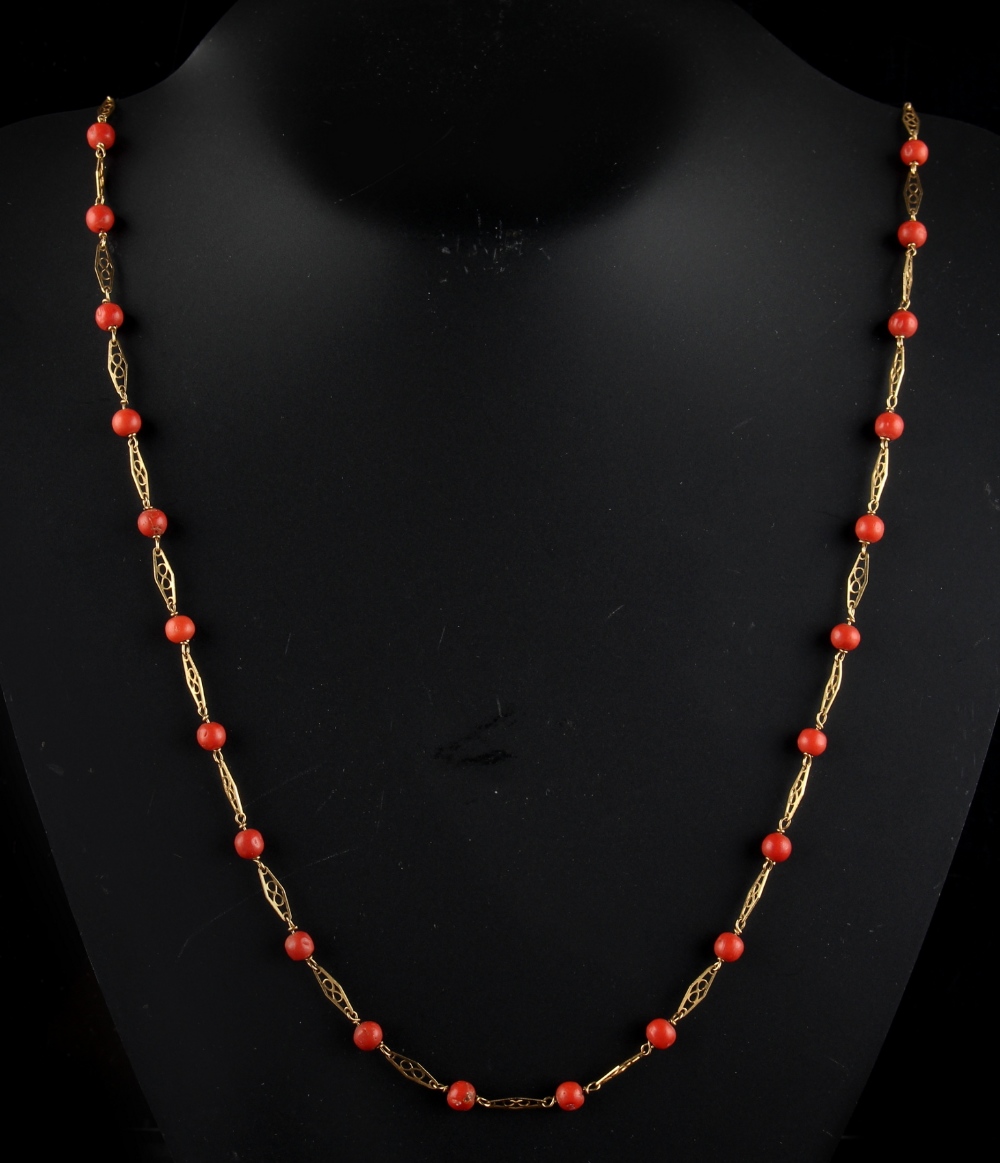A long 18ct yellow gold coral necklace, with pierced gold links alternating with coral beads each