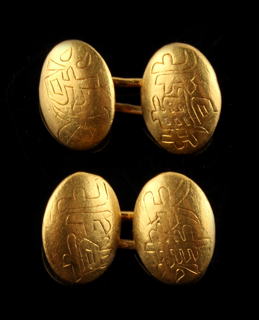 A pair of Chinese yellow gold (test 22ct) oval panel cufflinks, each engraved with two calligraphy