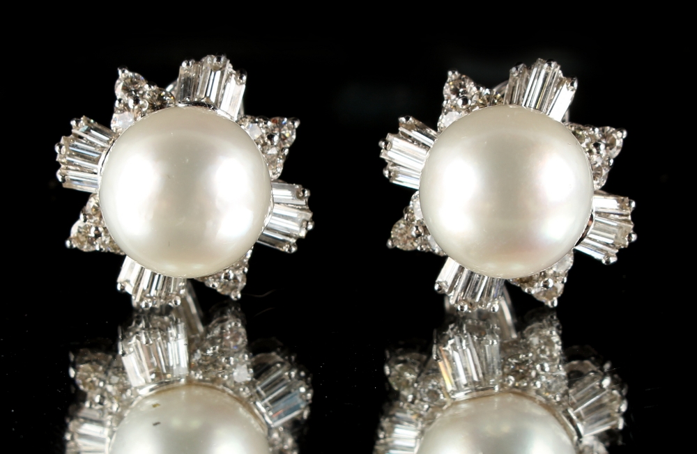 A pair of platinum pearl & diamond flowerhead cluster earrings, each with a large central pearl