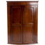 Property of a deceased estate - a George III mahogany bow-fronted two-door corner wall cabinet,