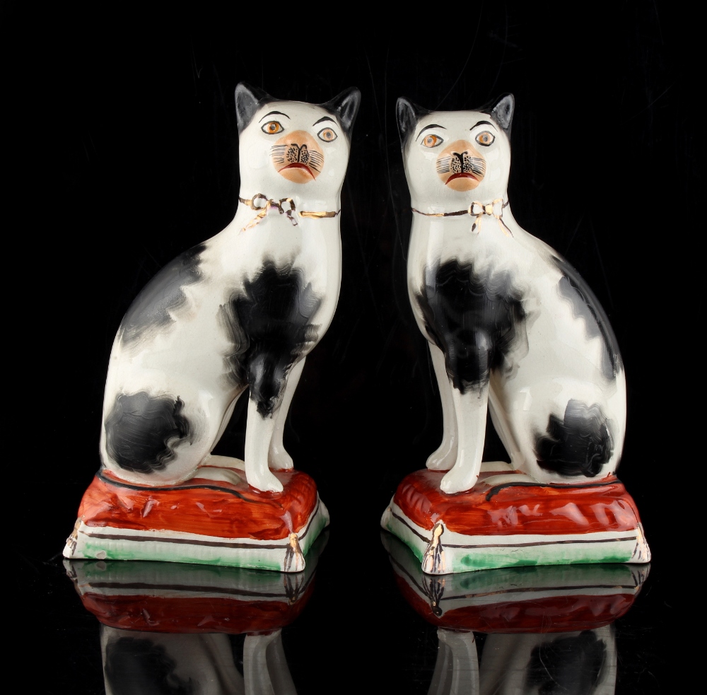 Property of a gentleman - a pair of early 20th century Staffordshire models of seated cats, on