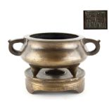 A Chinese bronze tripod two-handled censer on stand, probably late 19th century, with apocryphal