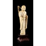 A 19th century Chinese carved ivory figure of a Lohan, modelled standing, holding a goblet &