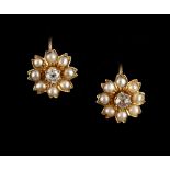 A pair of unmarked yellow gold diamond & pearl flowerhead earrings, each with a central Old European