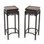 A pair of Chinese square topped stands, with carved & pierced friezes, each 23.8ins. (60.5cms.) high