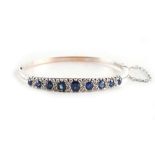 A white gold sapphire & diamond hinged bracelet, the nine oval cut sapphires weighing a total of