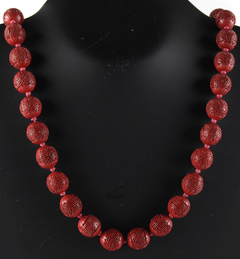 Property of a lady - a Chinese cinnabar lacquer bead necklace, the thirty-five individually