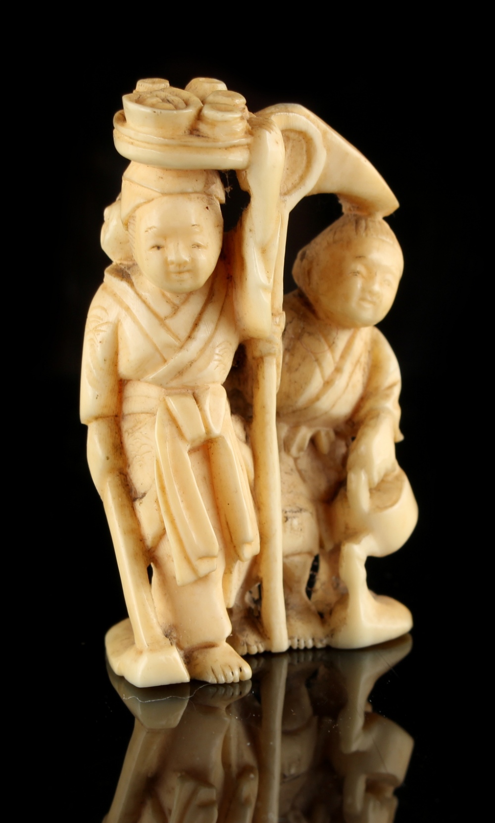 The Ronald Hart Collection of Japanese Netsukes - a carved ivory netsuke modelled as a standing lady