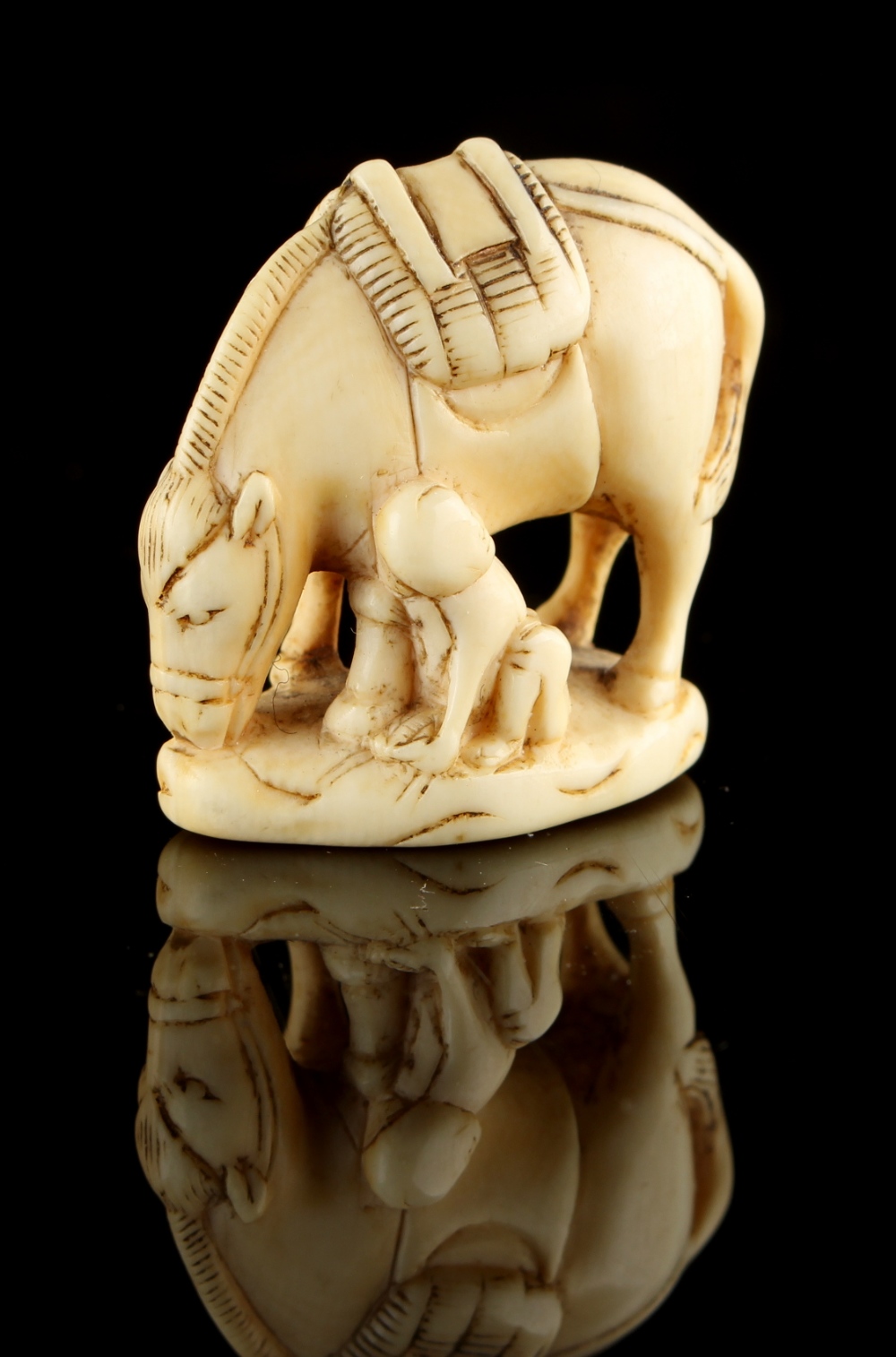 The Ronald Hart Collection of Japanese Netsukes - a carved ivory netsuke modelled as a boy seated by