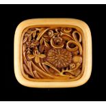 The Gill Collection of Japanese Netsukes - a carved ivory manju netsuke modelled as flowers in a