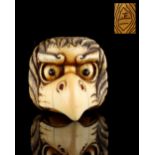 The Gill Collection of Japanese Netsukes - a carved ivory netsuke modelled as a karasu tengu mask,