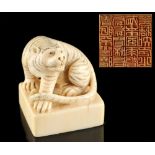 The Ronald Hart Collection - a carved ivory square seal modelled as a seated tiger, early 20th