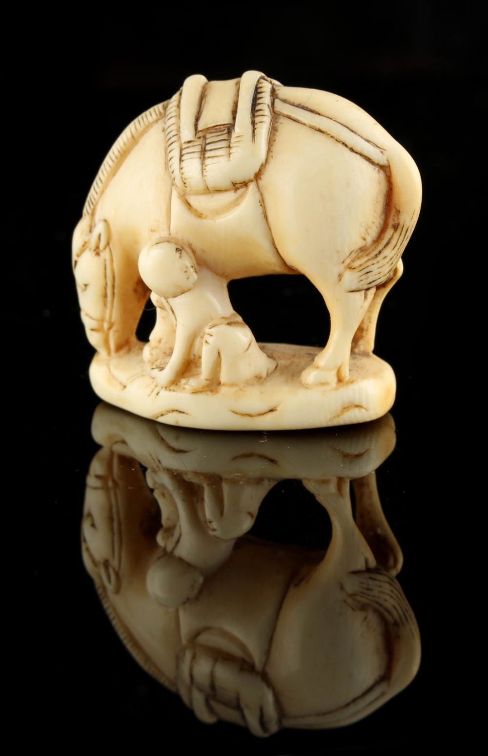 The Ronald Hart Collection of Japanese Netsukes - a carved ivory netsuke modelled as a boy seated by - Image 3 of 3