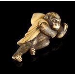 The Gill Collection of Japanese Netsukes - a carved ivory netsuke modelled as a recumbent monkey