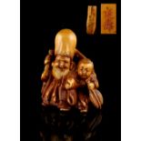 The Gill Collection of Japanese Netsukes - a carved ivory netsuke modelled as Fukurokuju with a boy,