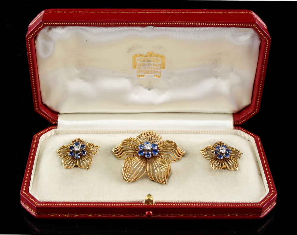 Cartier - a brooch and earrings suite comprising a pair of 18ct yellow gold flowerhead earrings,