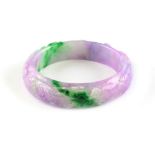 A Chinese lavender & apple green jadeite bangle, carved in relief with fish, 2.5ins. (6.3cms.)