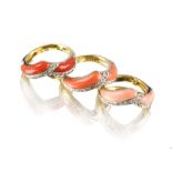 A set of three 18ct yellow gold coral & diamond interlocking 'V'-shaped rings, each ring with two
