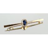 Property of a deceased estate - a yellow gold sapphire bar brooch, the oval cut sapphire weighing an