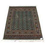 A Bokhara style rug with green ground, 75 by 53ins. (191 by 133cms.) (see illustration).