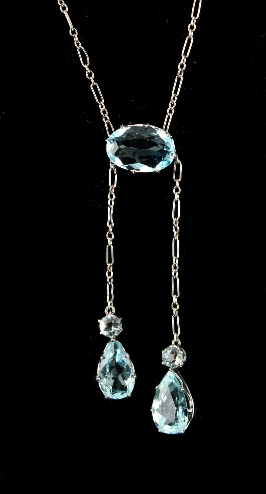 A 9ct white gold aquamarine necklace, of asymmetric design with two pendants of differing lengths,