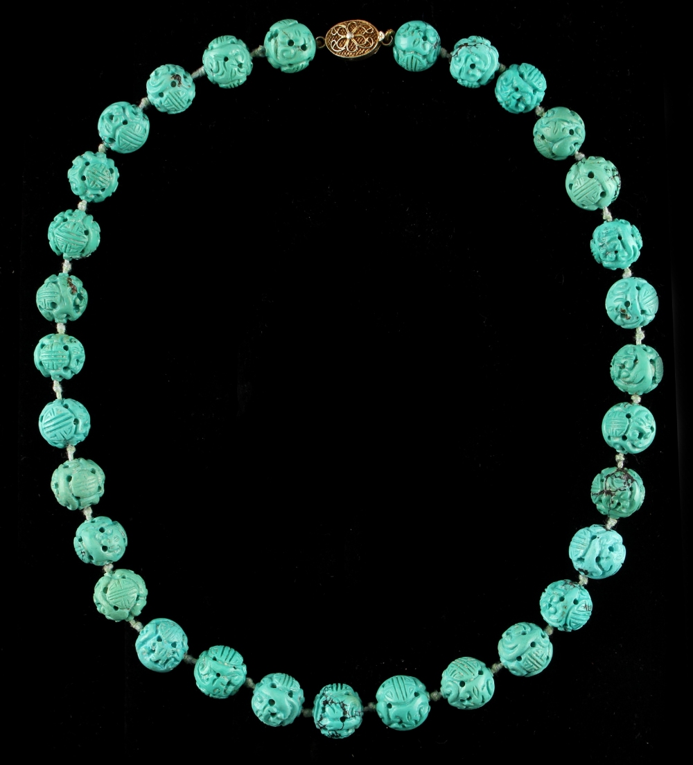 A Chinese carved turquoise bead necklace, the thirty-one uniform beads each carved with two shou