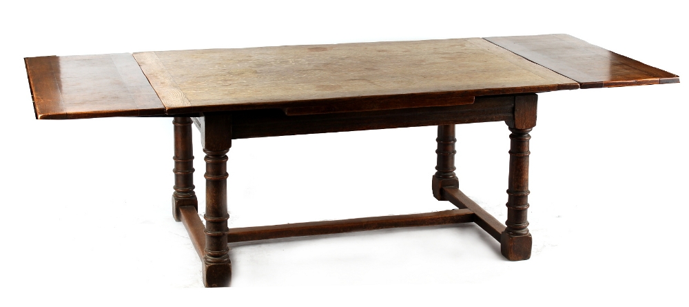 Property of a gentleman - a Cromwellian style oak draw-leaf dining table, with turned legs united by