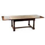 Property of a gentleman - a Cromwellian style oak draw-leaf dining table, with turned legs united by