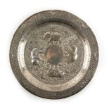 An Indian white metal (tests silver) circular plate, decorated in repousse with elephants,