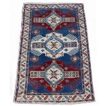 Property of a deceased estate - an early 20th century Caucasian Kazak rug, with navy field, 76 by