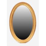 Property of a lady - an Edwardian gilt oval framed wall mirror, re-gilt, 31ins. (78.5cms.) high (see