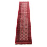 Property of a lady - an Afghan runner, late 20th century, with red ground, 132 by 31ins. (336 by