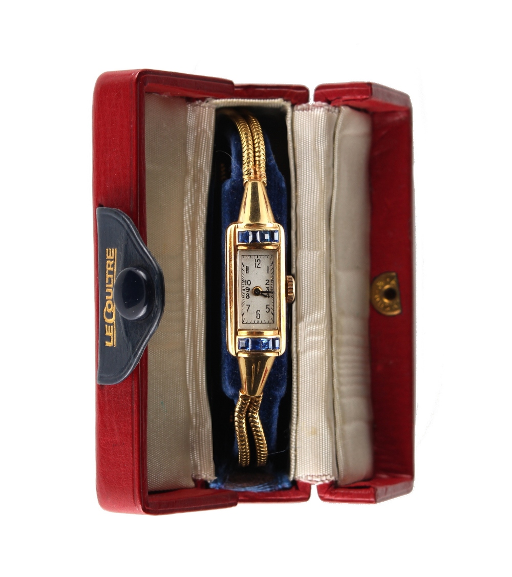 An Art Deco 18ct yellow gold tank cased wristwatch, the case set with calibre cut sapphires, with