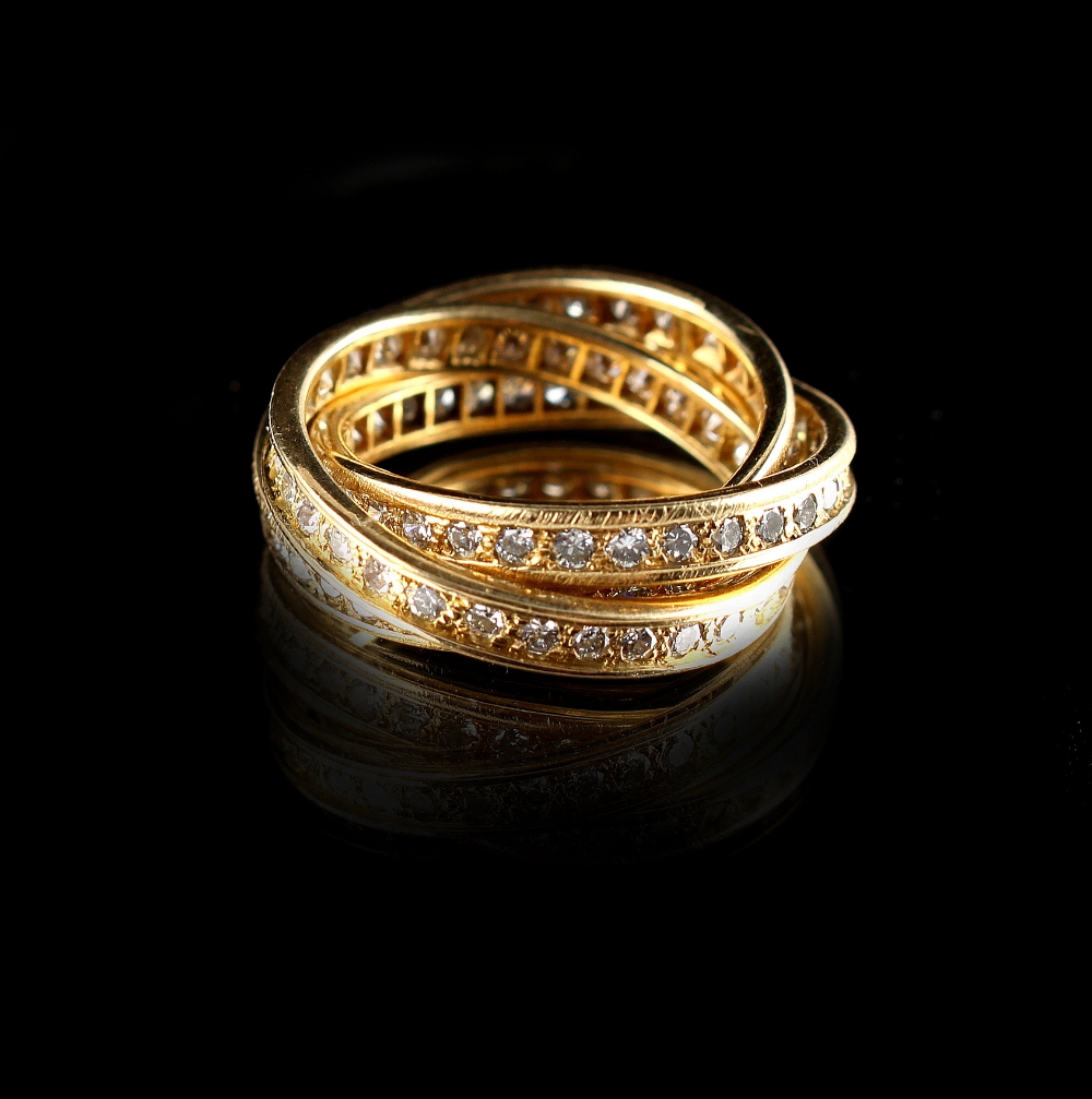 An unmarked yellow gold diamond set Russian wedding ring, the three linked rings set with round