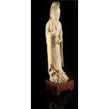 A 19th century Chinese carved ivory figure of Guanyin, modelled standing on a dragon & holding a