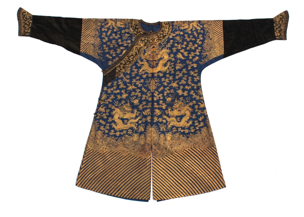 A Chinese blue silk dragon robe, late 19th / early 20th century, worked in couched gold threads with