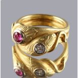 A yellow gold ruby & diamond twin snake ring, the heads inset with a round cut ruby & a round