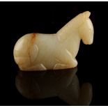 A Chinese Ming style creamy white & russet jade carving of a recumbent horse, 2.55ins. (6.5cms.)