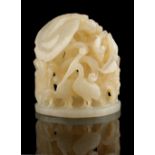 A Chinese carved very pale celadon jade hat finial in the form of egrets among flowers, 2ins. (5.